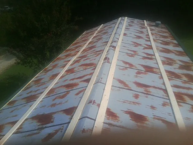 Rusted metal roof panels with new wood purlins before replacement — Storm Damage Roof Repair in North Ridgeville by Roofing Brothers