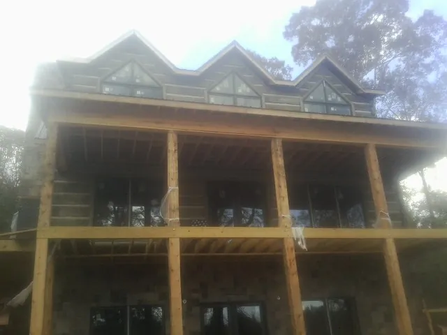 Dormers and porch framing on a large log home under construction — Roof Coating work by our crew in North Ridgeville