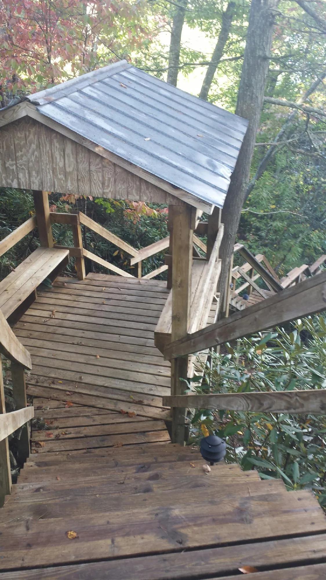 Metal roofed shelter over wooden steps on a wooded walkway — Skylight Repair & Installation work by our crew in North Ridgeville