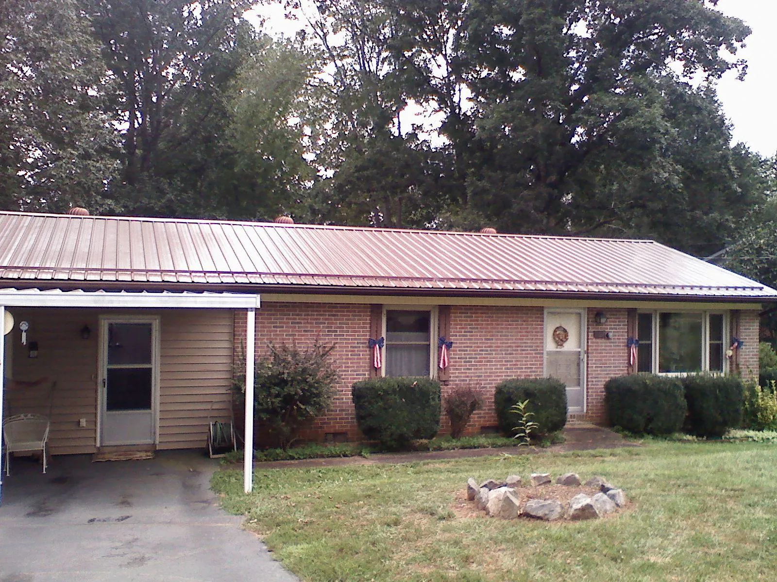 Bronze metal roof and carport on a brick ranch home — Roof Repair work by our crew in North Ridgeville